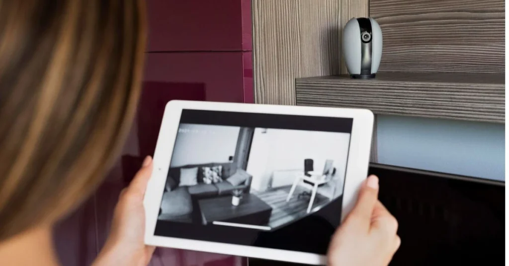 Women monitor home security cameras.